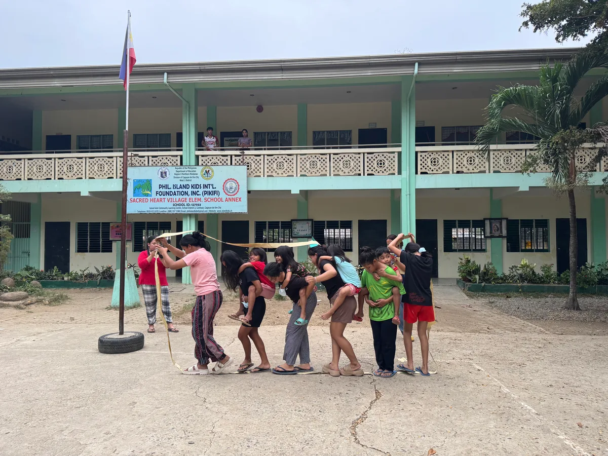 Trotz Ferien ist der Schulhof stark belebt. Bei gemeinsamen Spielen wachsen die Kinder und Jugendlichen noch mehr zusammen. Kinder, die auf dem Schulhof spielen.